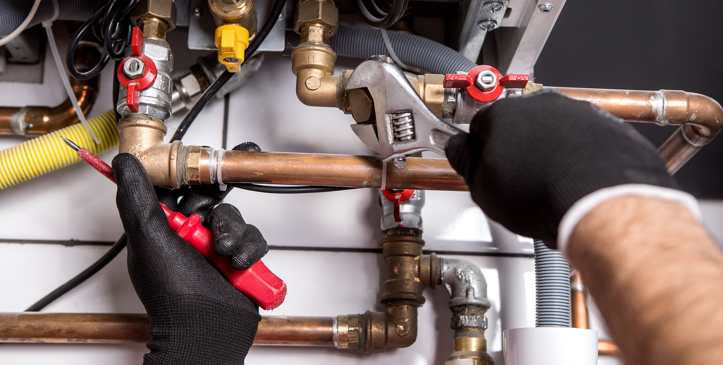 Plumber performing emergency commercial plumbing work on copper pipes